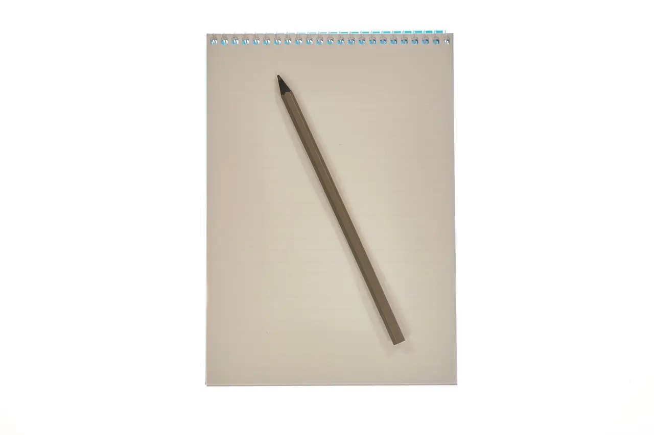 A blank notepad and a wooden pencil on a tidy desk